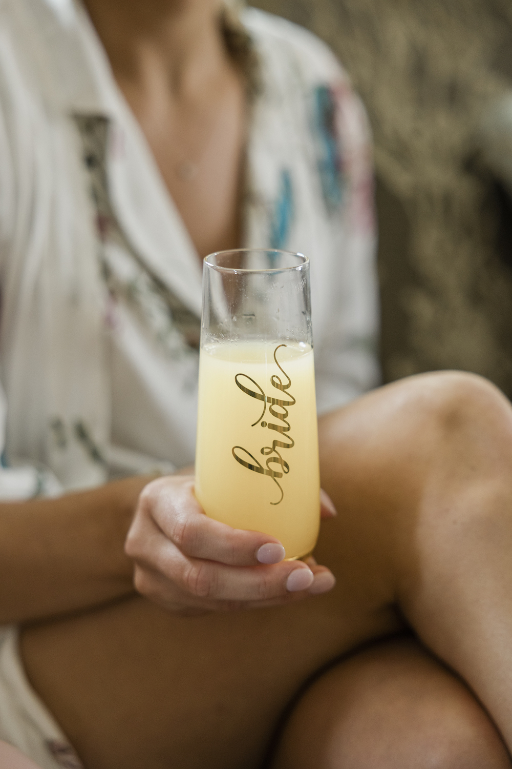 Close-up shot of bride in her pajamas holding her glass with an engraving that reads 'Bride' on it during their wedding shoot with Michigan Photographer Holly Kattlegreen