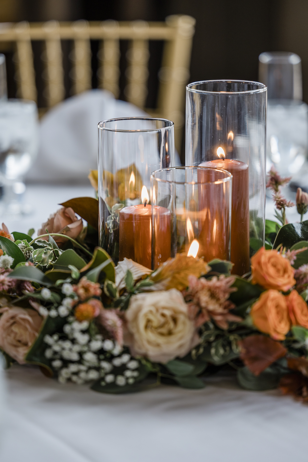 How To Create A Wedding Day Timeline in 5 Easy Steps: Close-up shot of floral and candle centerpiece on a wedding reception table.